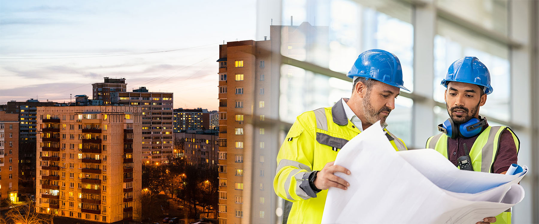 Kaupunkimaisemaa jossa kerrostaloja, projektityöntekijät tutkimassa kaavoja