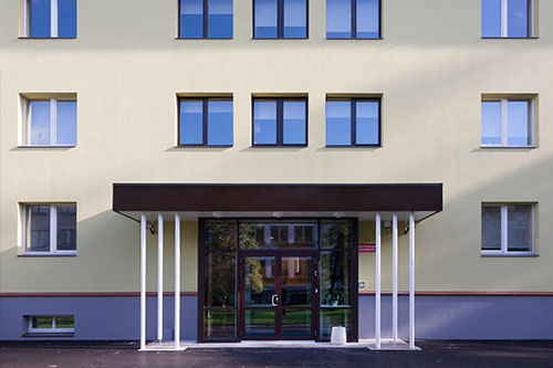 Vaalean kerrostalon julkisivu ja edusta